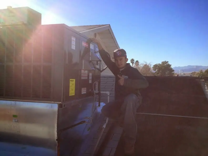 HVAC technician performing AC Tune-Up on a rooftop unit in Surfside